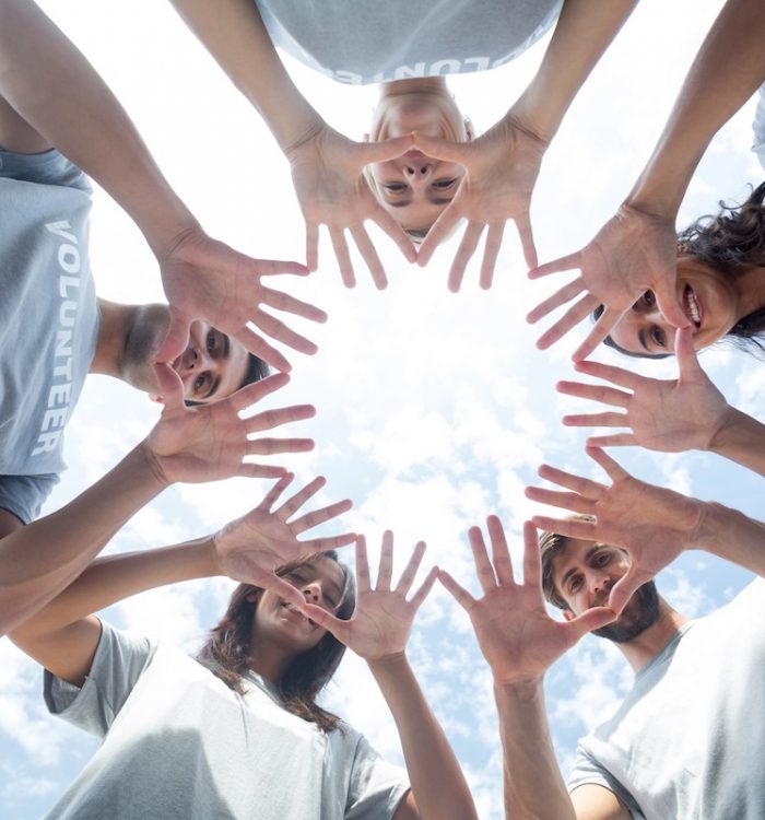 Low angle of happy volunteers playing with their hands